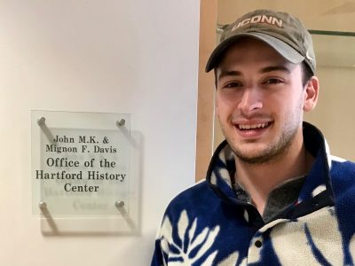 Male Student in front of Office of the Hartford History Center Sign